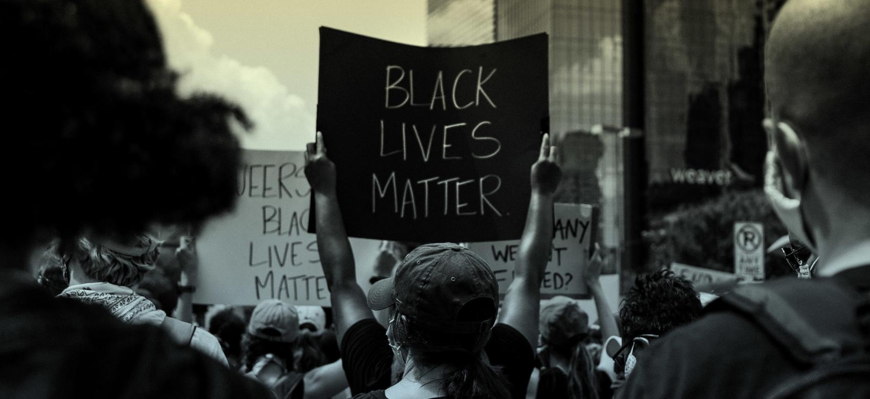 A group of people holds anti-racist signs at a Black Lives Matter protest