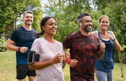Healthy group of multiethnic middle aged men and women jogging at park