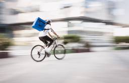 A gig economy worker on the bike riding in the city