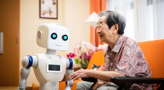A robot in a retirement home with a happy old woman.