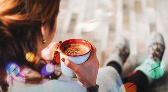 A women drinks hot chocolate to improve her mental health over the holiday season