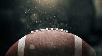 Photo of a football on a dark background with moisture surrounding it