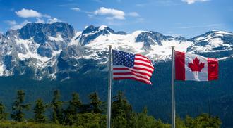 Canadian and American flags in the mountains