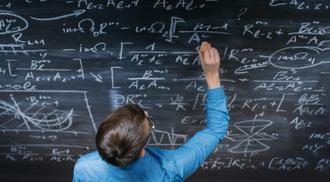A photo of a student writing mathematical formulas on a blackboard.