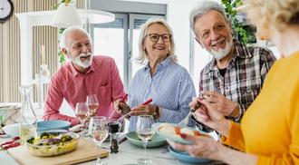 Photo of a senior group of friends having lunch and hanging out at home.
