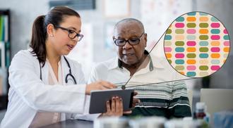 A doctor and a senior patient look at the patient's personalized genomic sequencing results on a tablet in a doctors office