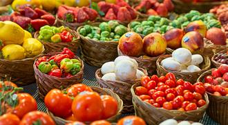 A bustling fruit stand filled with a variety of fresh fruits and vegetables at the historic St. Lawrence Market in downtown Toronto, Ontario, Canada
