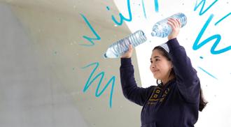 A person does an exercise workout by using water bottles as weights