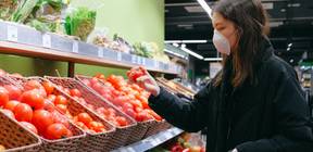 A women looks at tomatoes in a store